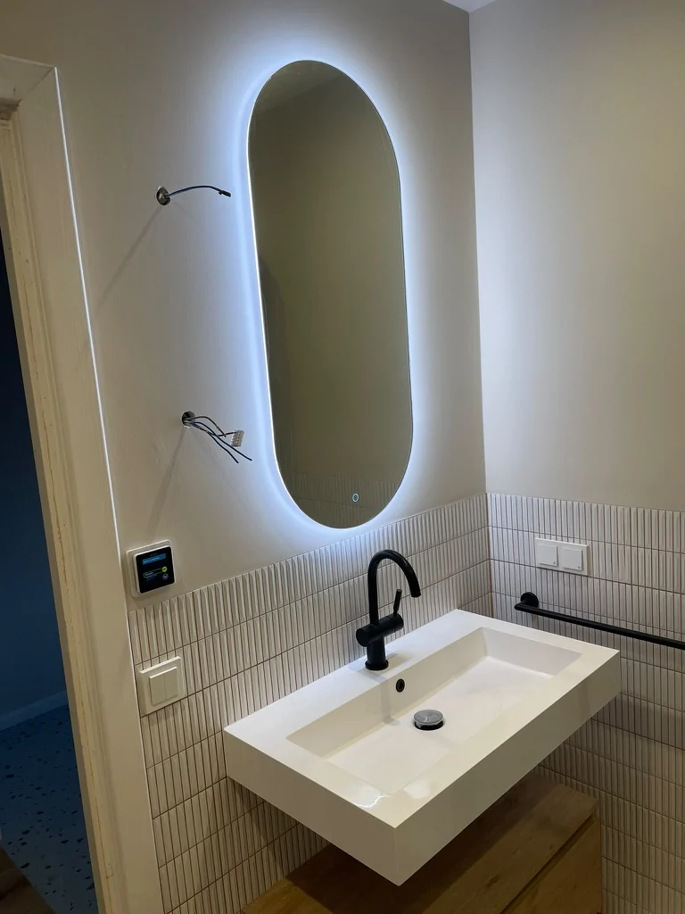 Wastafel en verlichte spiegel