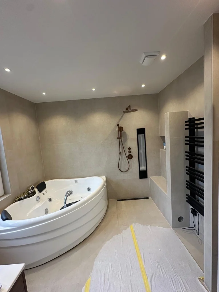 Badkamer met hoekbad en douche